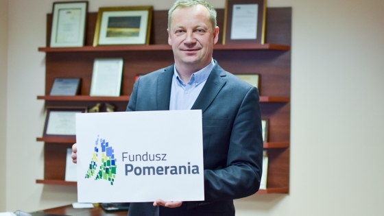 Adam Badach, szef Funduszu Pomerania, prezentuje jego nowe logo 