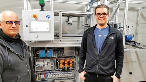 Inżynierowie Sławomir Jaszczak z Wydziału Informatyki ZUT (pierwszy od lewej) oraz Kamil El Fray z firmy Endeavour
Lab na tle maszyny do produkcji przyłbic. 